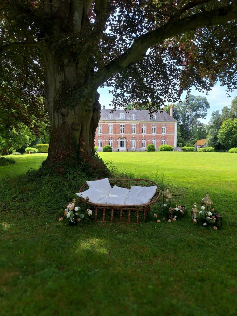 Assise des mariés lors d’une cérémonie laïque décorée dans un domaine de mariage en Normandie