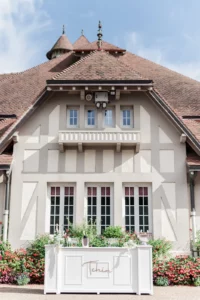 Bar blanc mariage en bois, modèle Patrick, installé en extérieur devant un bâtiment normand pour un mariage élégant.