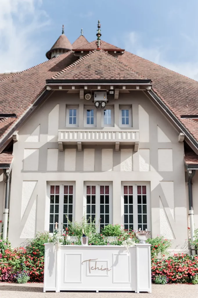 Bar blanc en bois, modèle Patrick, installé en extérieur devant un bâtiment normand pour un mariage élégant.