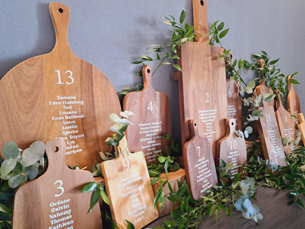 Plan de table créé avec des planches en bois stockées et feuillage, un exemple de décoration disponible en location déco mariage.