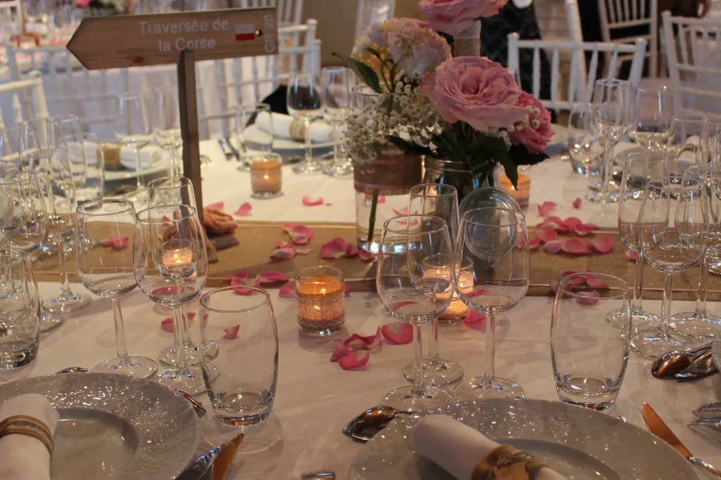 Décoration de table de mariage champêtre avec chemins en toile de jute, roses anciennes et bougies, revisitée dans une version plus élégante.