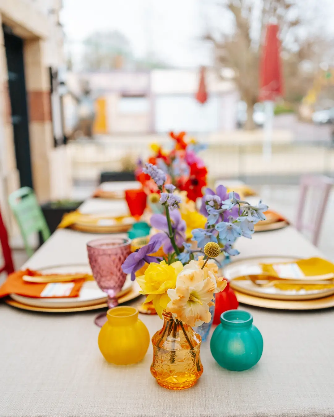 Décoration de table colorée pour un mariage de printemps avec fleurs vives et verrerie vibrante.