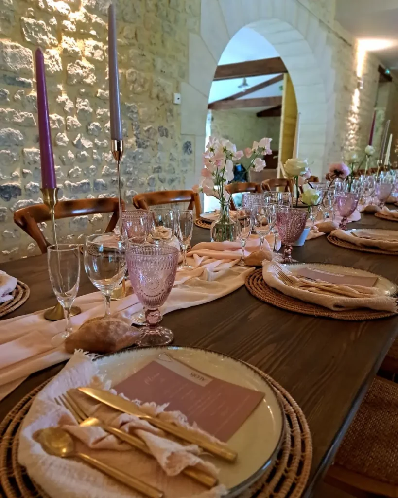 table de mariage de printemps aux couleurs fraiches, avec verres roses poudré, fleurs délicates et bougies pour une ambiance délicate et moderne