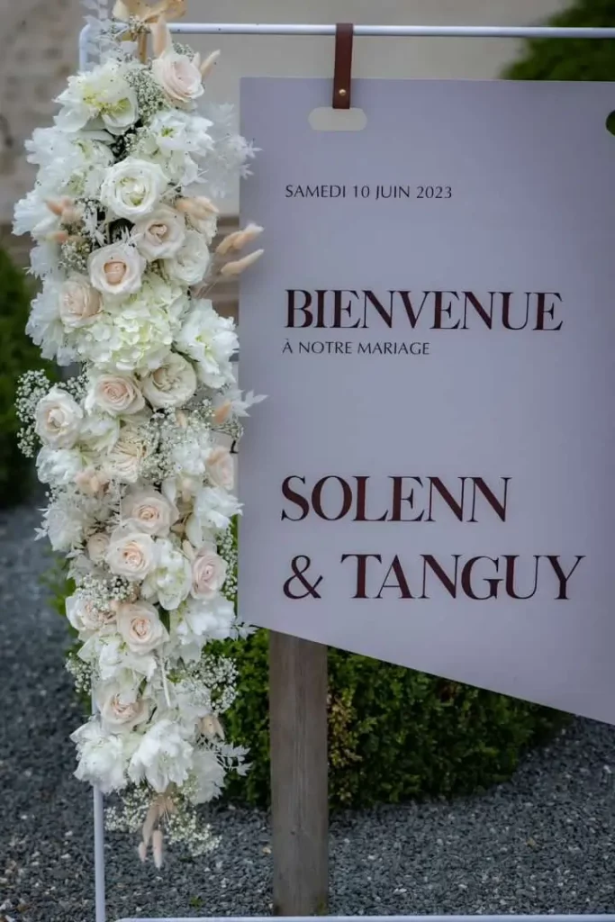 Panneau de bienvenue fleuri pour accueillir chaleureusement les invités d’un mariage.