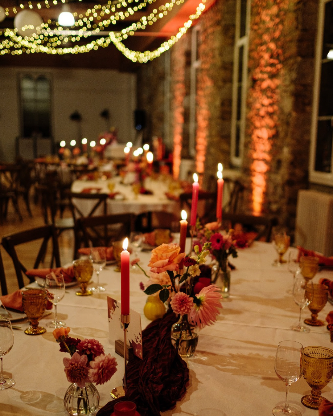 Ambiance cohérente pour ce mariage élégant - Décoration de mariage élégante au domaine de la Guérie en Normandie (centre de table fleuri, bougies, art de la table soigné et guirlandes lumineuses), photographiée par Audrey Guyon avec les fleurs de Maison Magnolia.