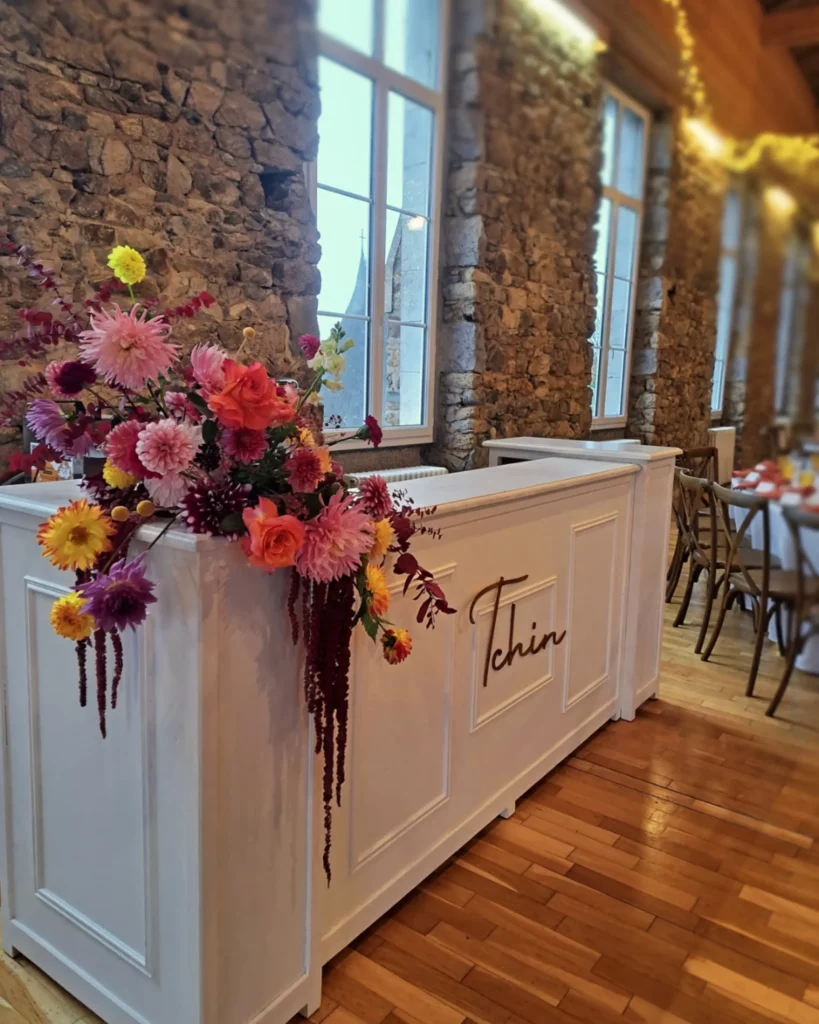 Bar Patrick décoré au domaine de la Guérie avec une composition florale colorée de Maison Magnolia, illustrant la création d’une ambiance cohérente et élégante pour un mariage. Photo Audrey Guyon.
