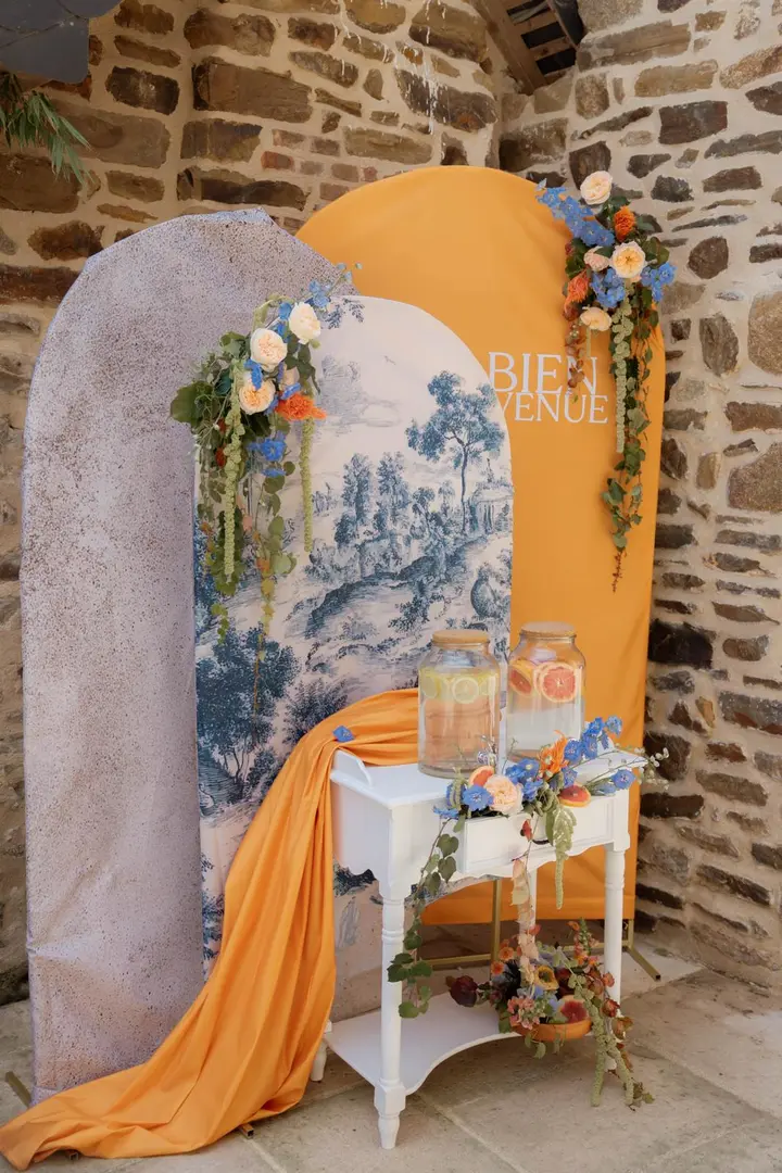 Direction artistique, thème de mariage bleu et pêche avec toile de Jouy, fleurs et scénographie personnalisée.