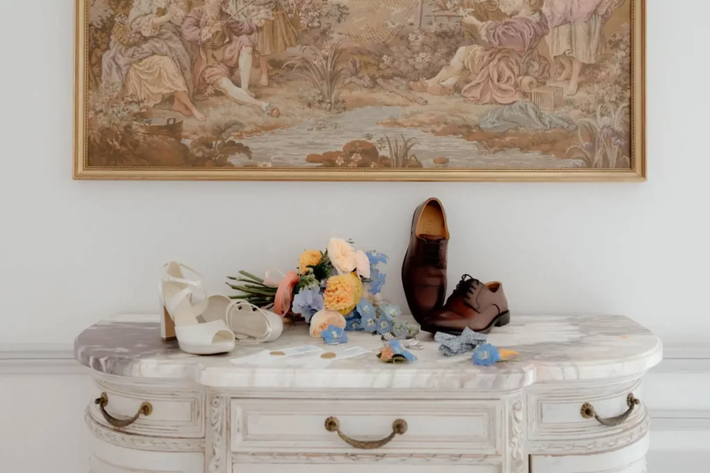 Détails du marié coordonnés autour d'un même thème de mariage avec papeterie, accessoires et boutonnière assortis.