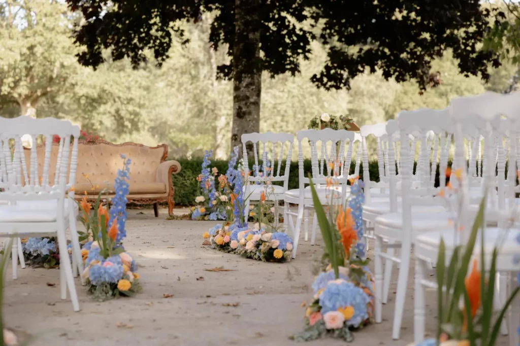 Cérémonie de mariage bleu et pêche où fleurs, mobilier et scénographie reprennent les mêmes codes visuels.