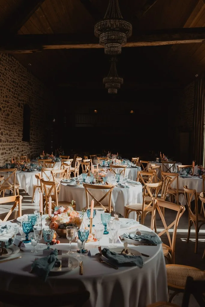 alle de mariage aux lustres, tables rondes dressées et couverts identiques en enfilade